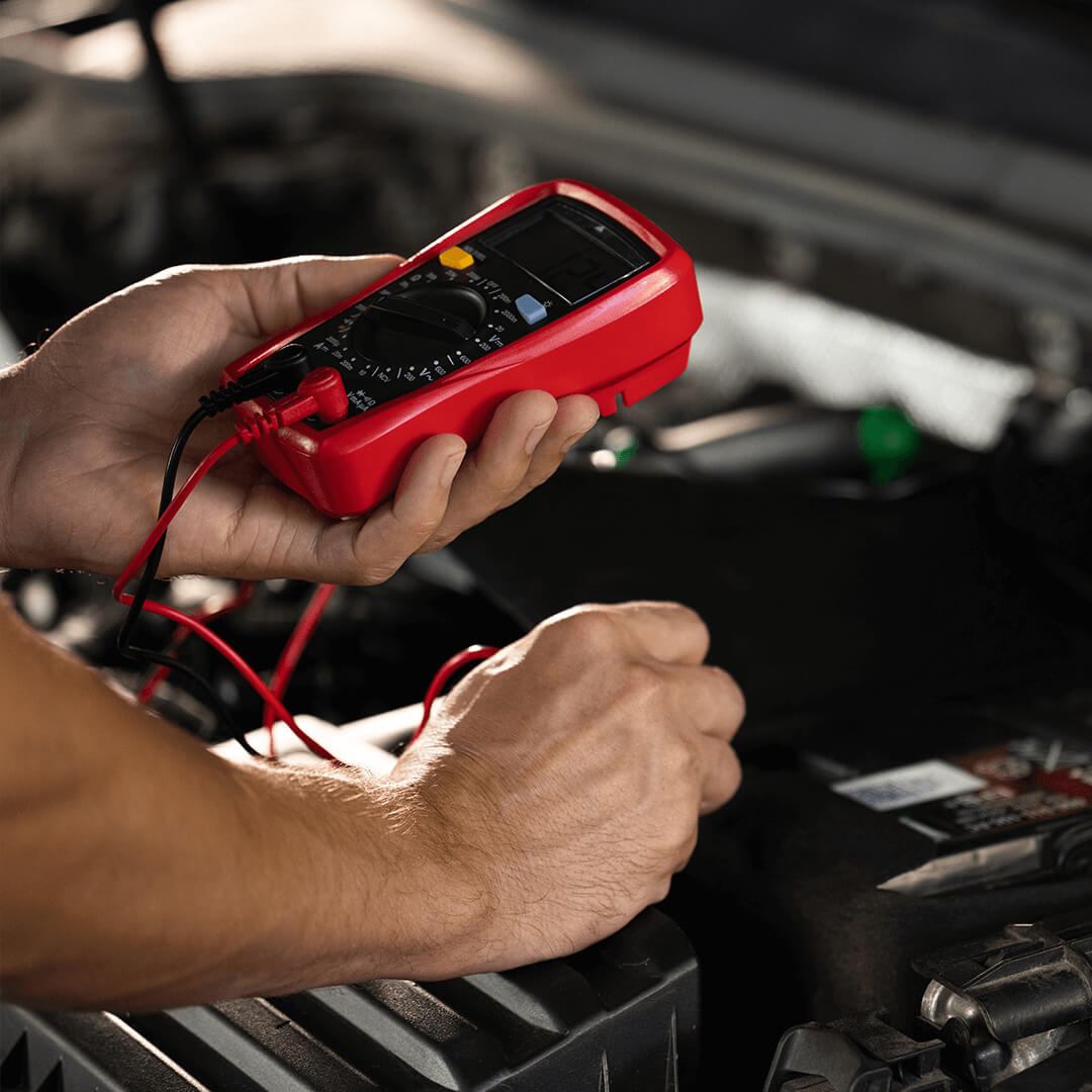 Diagnosing a Buick car with a red color multimeter underhood