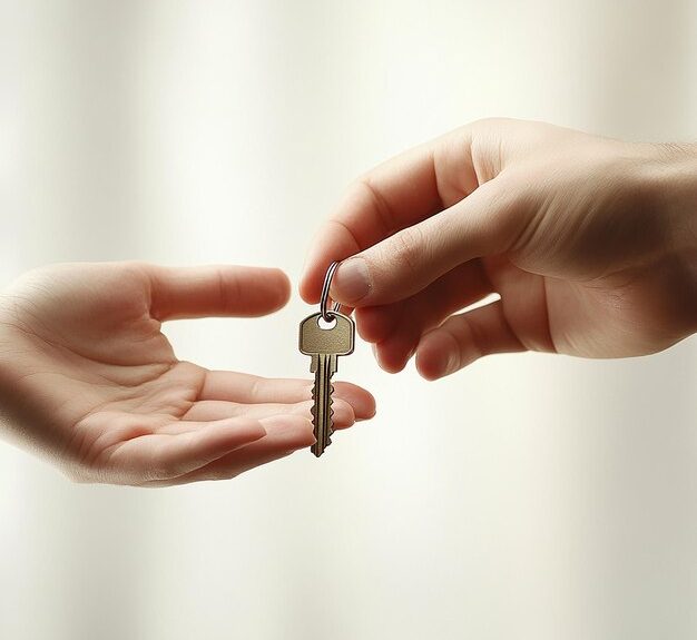 A hand on the right passes a master key to a hand on the left, set against a light, blurred background.