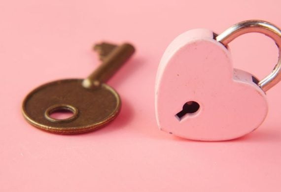 a heart shaped lock and a key on a pink background