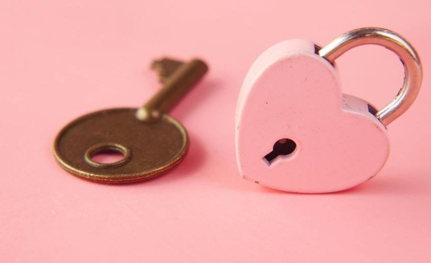 a heart shaped lock and a key on a pink background