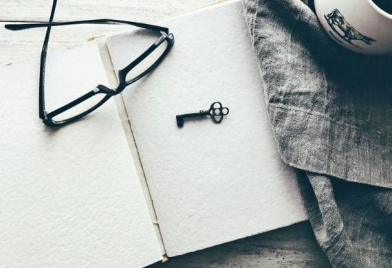 eyeglasses and skeleton key on white book