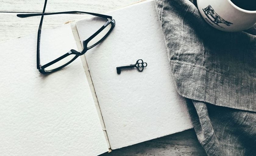 eyeglasses and skeleton key on white book