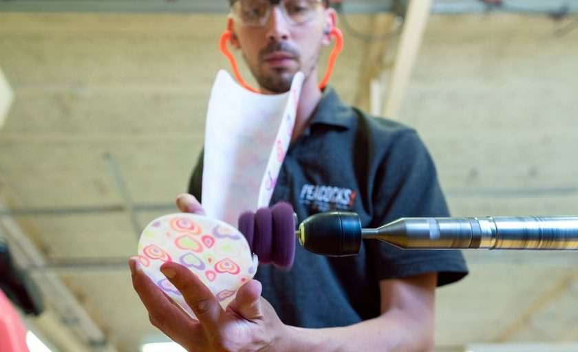 man in black polo shirt holding pink and white floral ceramic mug