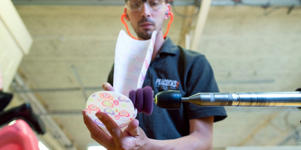 man in black polo shirt holding pink and white floral ceramic mug