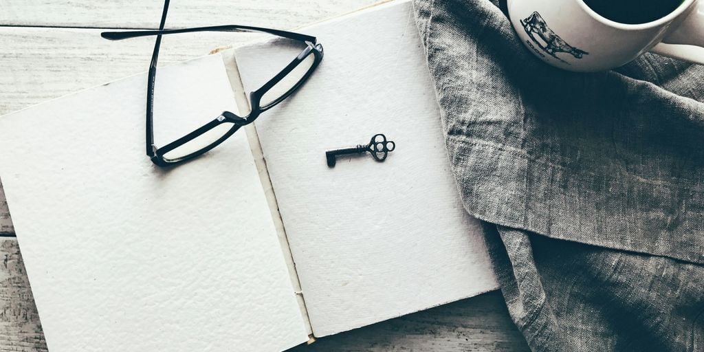 eyeglasses and skeleton key on white book