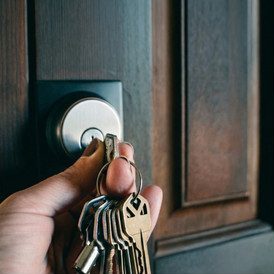 Residential locksmith Vancouver, hand with keys unlocking a residential door lock